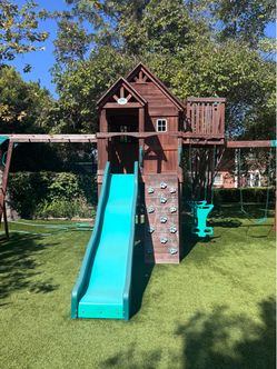 Skyfort II Outdoor Playground Set w/ Monkey Bars, Upper Fort, Crow's Nest, Belt Swing Set, Picnic Table, and Rockwall.
