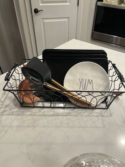 Pretty heavy metal Black Wire Kitchen Basket with Handles, plates, copper colored utensils, and extra pieces