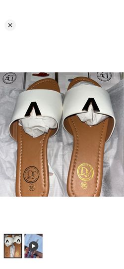 DE white slide sandals with a gold V accent.
