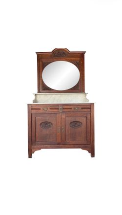 French antique oak washstand / vanity with a marble top, oval beveled mirror, and floral carvings