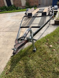 17x7 custom built single-axle steel boat trailer with wooden bunks and a tongue jack.