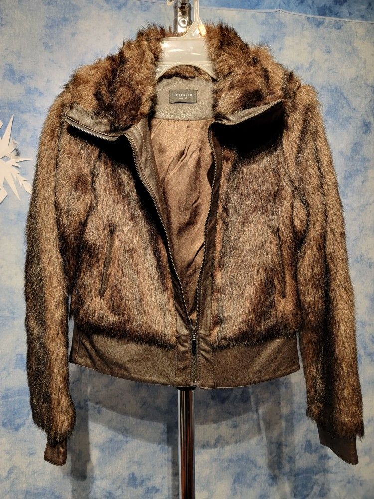 off-duty bomber style perfected. Fashioned from plush faux fur. Stand collar. Rib knit cuffs and hem. Leather-trimmed zip ...