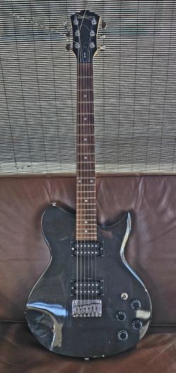 Washburn WI14 Idol Series electric guitar in a black finish. 
It features a single-cutaway solid body design.

