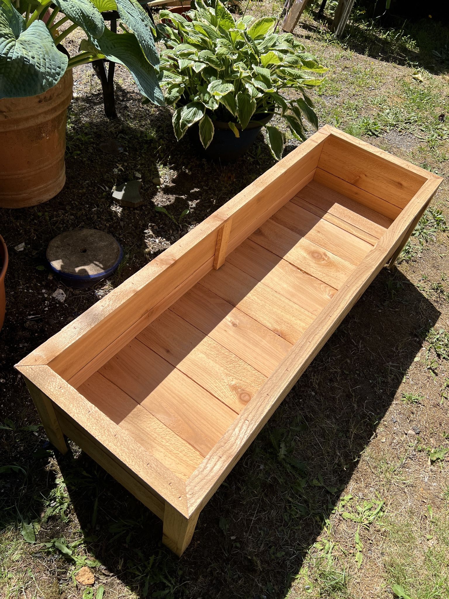 A container made of cedar wood designed for planting flowers & More.
