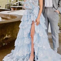 Charming light blue gown with ruffled layers and delicate lace. Ideal for special events.