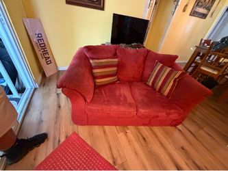 Red loveseat with two pillows