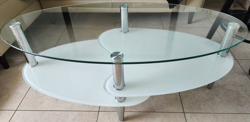 modern oval glass coffee table with a frosted lower shelf and metal