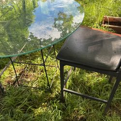 A Beautiful High Glass Table With Two Black High Chairs 