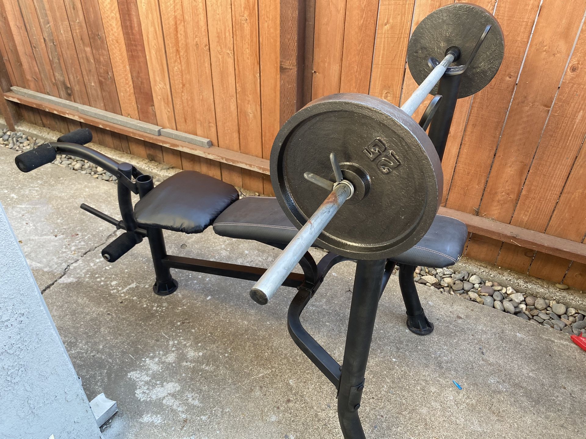 Weight bench with barbell and 2 25 lb cast iron plates