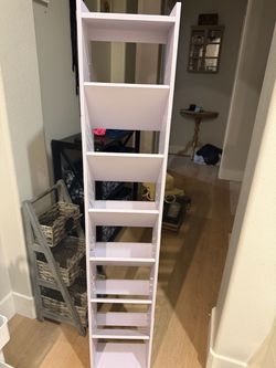 White multi-tier storage tower has seven slanted shelves