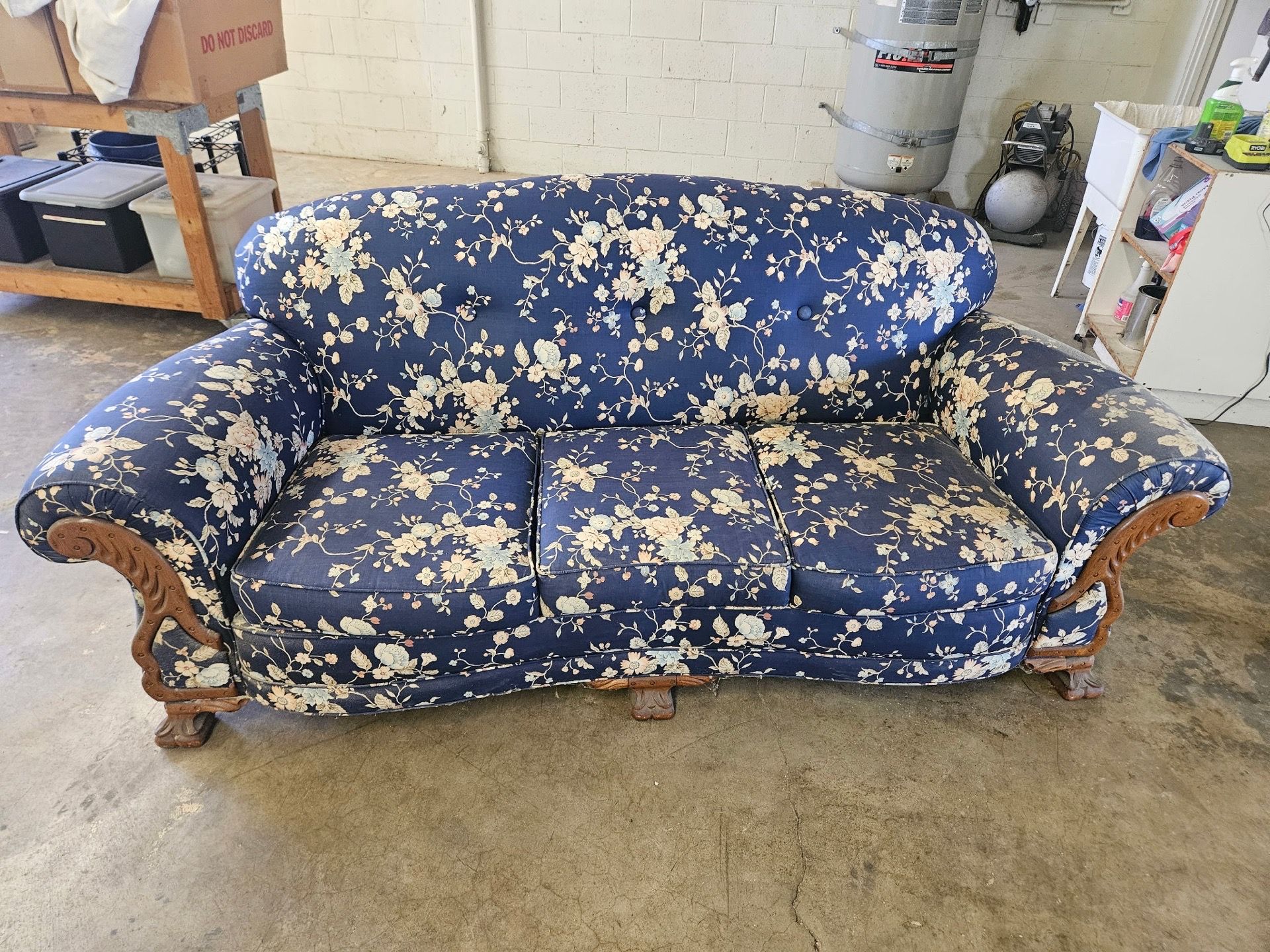 Blue floral sofa with carved wood details