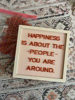 Light pink/beige letter board with dark orange letters