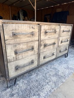 rustic industrial-style 9 drawer dresser with a weathered whitewash wood finish and metal pipe-style handles.