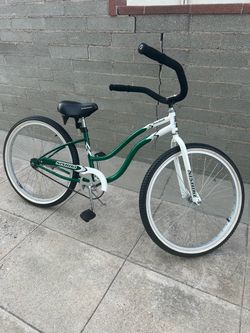 Single speed, green and white Nishiki Boardwalk beach cruiser