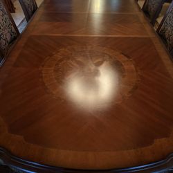 Formal dining table with 2 arm chairs, 10 additional chairs with no arms, and sideboard
