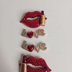 The Bling Croc Charms Red Lips Love Lipstick features a set of four shoe charms, each designed in the shape of lips. Made of plastic, these charms are