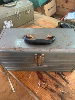 vintage gray metal Craftsman toolbox featuring a ribbed front panel and a black plastic handle.