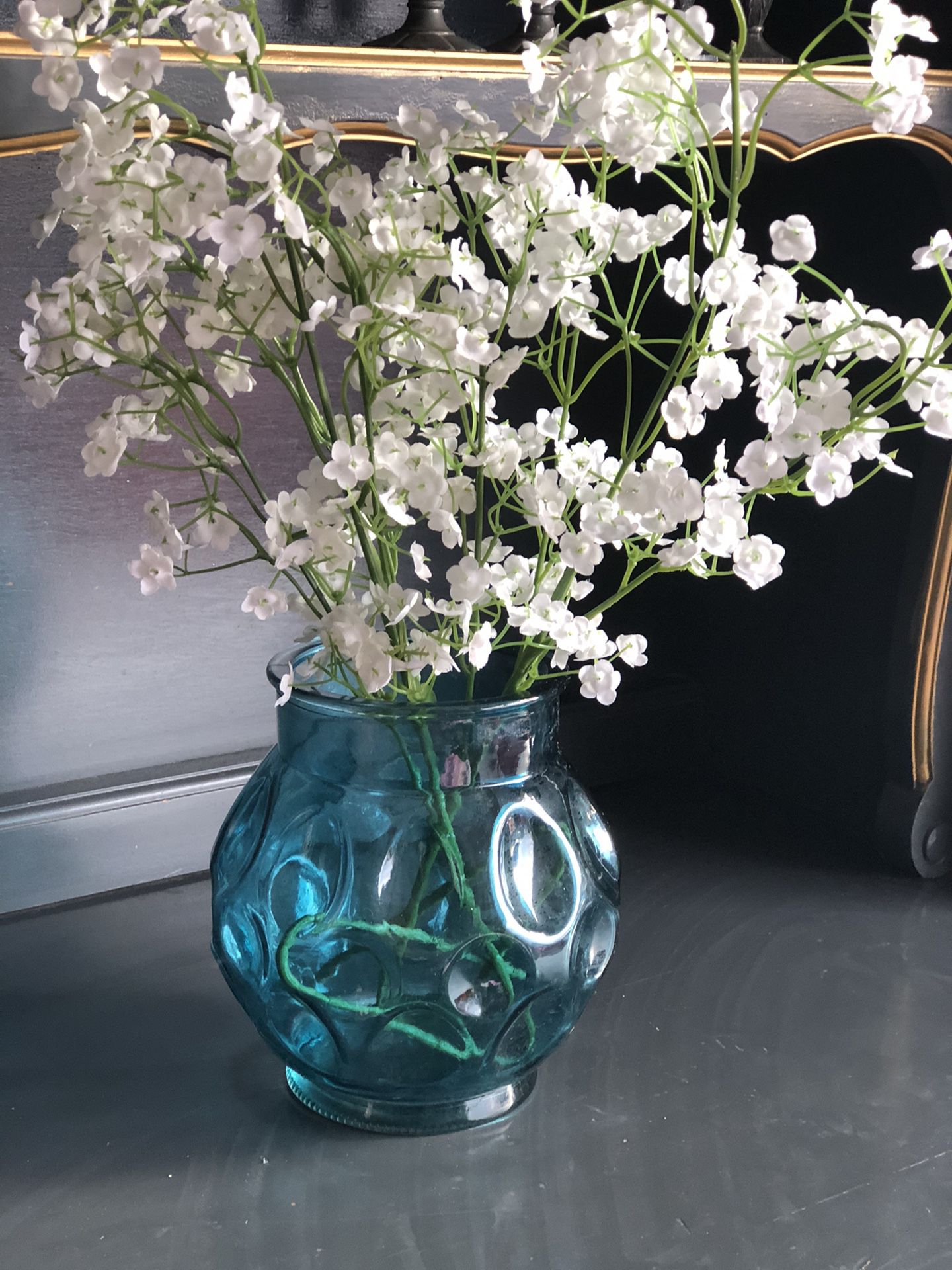 Teal glass vase with faux flowers