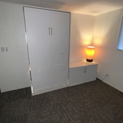 Twin white Murphy wall bed with mattress and cabinet
