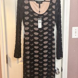 BCBG black lace bodycon dress with long sleeves and cutout details. Size: XS 