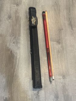 two-piece pool cue with a red-and-black wrap/butt section, a maple shaft, and a black hard case