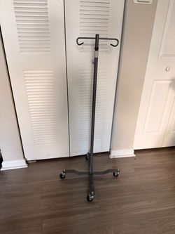 a height-adjustable, 4-leg rolling IV pole designed to support intravenous bags or medical equipment during patient care
