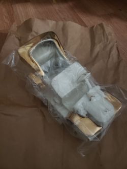 A White decorative ceramic/ porcelain car with gold accents