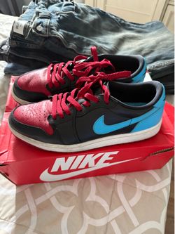 are Nike Air Jordan 1 Retro Low OG "NC to Chi" sneakers, featuring a black tumbled leather upper with powder blue and gym red accents