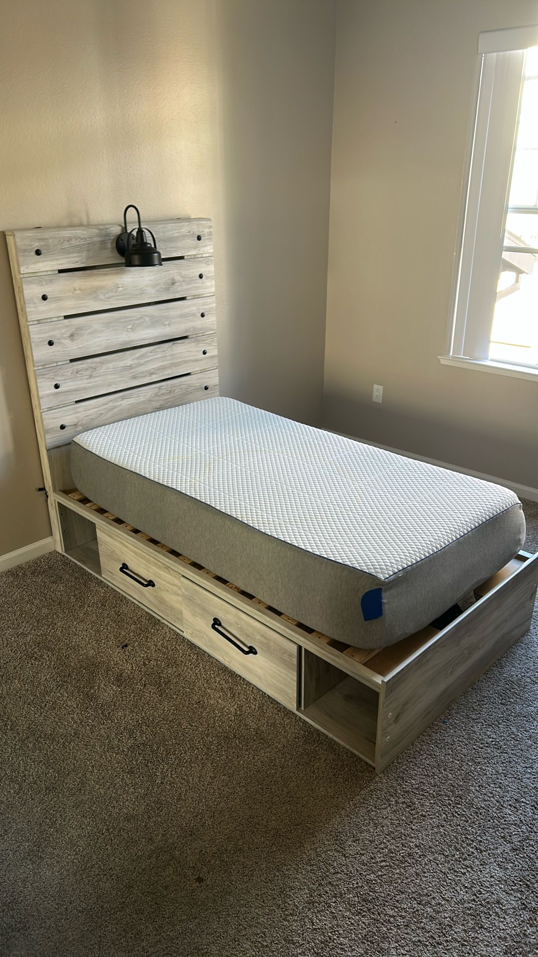 Children's twin bed with mattress, boxspring, lamp, and drawer with posters