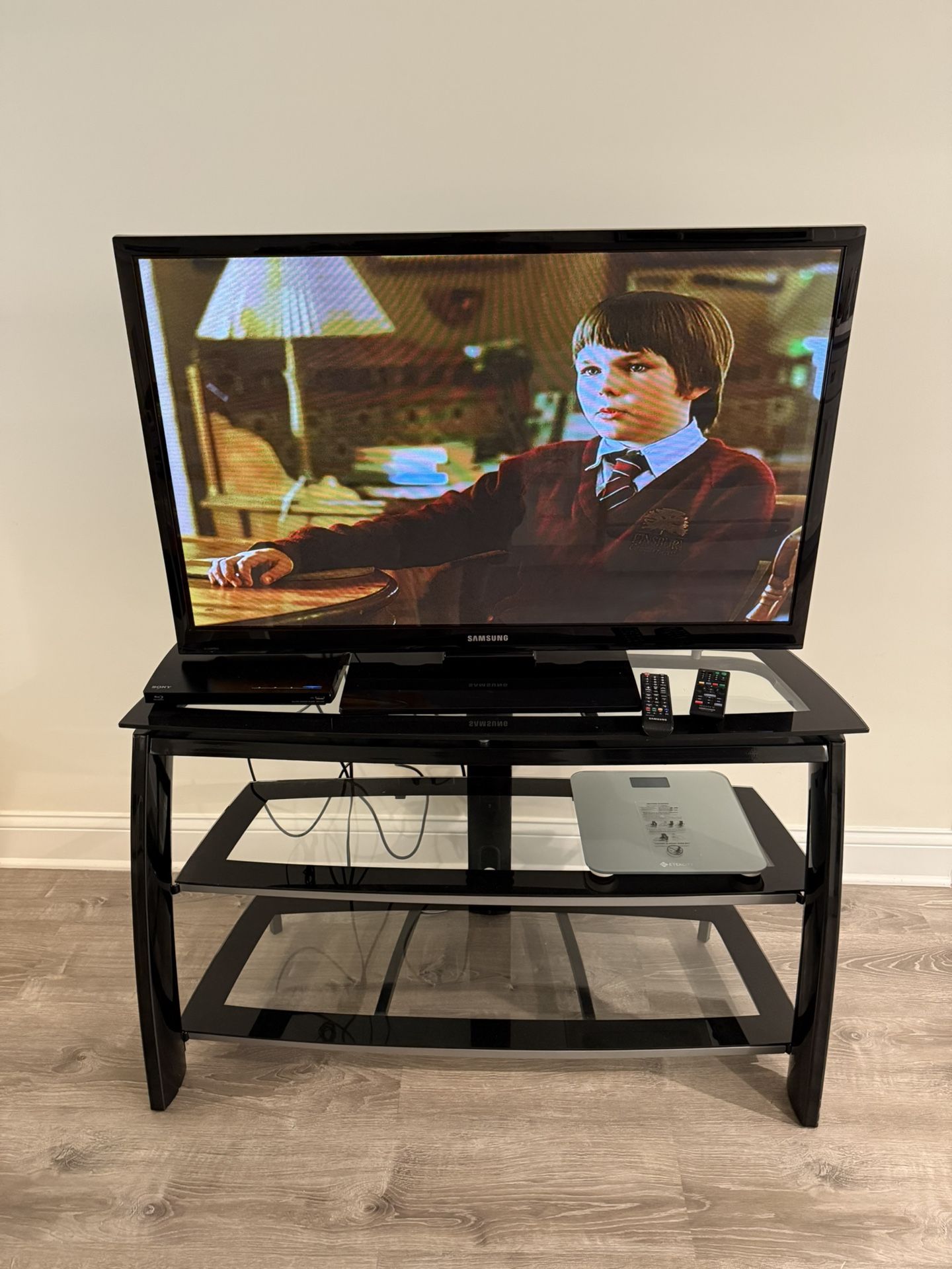 NICE AND MODERN TV STAND WITH THREE GLASS SHELVES. IT MEASURES 45 BY 27 BY 15 INCHES. $60.00 OR BEST OFFER.