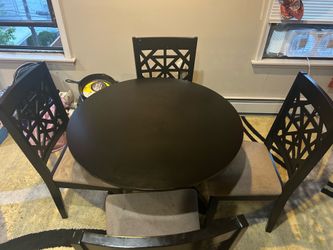 Round dark wood dining table with 4 chairs