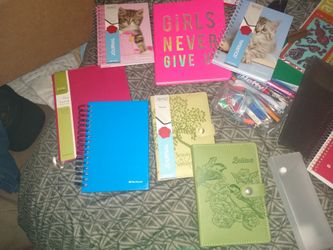 Several journals paper stapler pens and pencils ect
