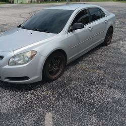 Red Nissan Rogue And Grey Malibu Chevy
