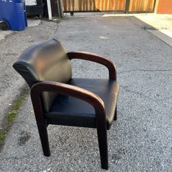 Comfortable vintage office guest chair with a sturdy solid-wood frame and classic curved arms. The vinyl seat and back appear clean but do show some c