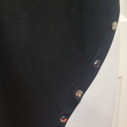 Tommy Hilfiger Women's Asymmetric Scuba Sheath Dress, which features a black and white color-block design with an asymmetrical hem and decorative gold