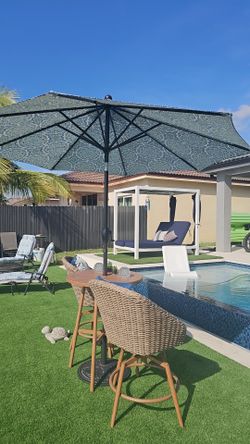 Bistro table with chairs and umbrella.