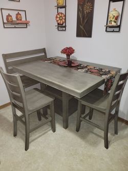 Counter height dinette set.     3 chairs 1 bench.  Table  54x42 extends to 54x65 with leaf.  Heavy, great condition.