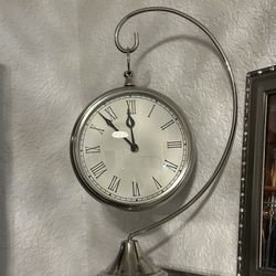 Clock Hanging On A Silver Base 