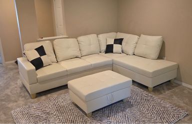 White leather sectional couch and ottoman