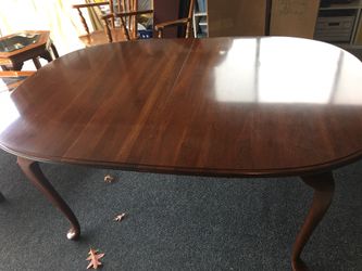 Elegant Queen Anne cherry dining table. With two 14” leaves. Includes pads for entire table