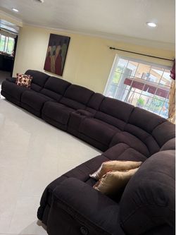 Beautiful oversized sectional sofa with multiple reclining seats and two matching recliners.