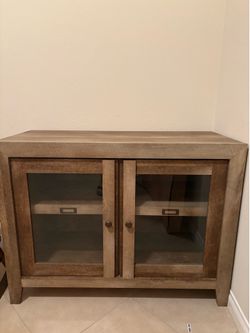 Wooden cabinet with shelves and glass doors.