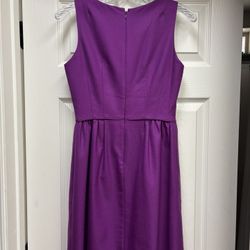 This stunning J. Crew dress in a rich purple hue features a pleated design that adds a touch of elegance to its sheath silhouette. Perfect for cocktai