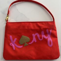Kate Spade red nylon pouch with pink "kny" lettering and a gold spade logo