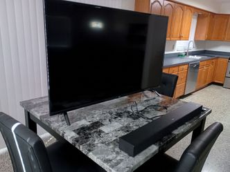 Fifty inch Roku TCL tv with soundbar and remote