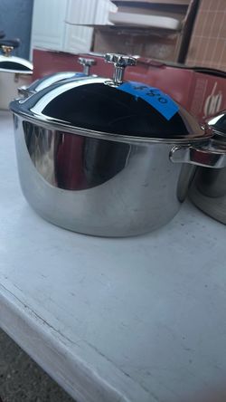 titanium stockpot with a fitted lid and metal knob handle. Mirror finish with minor surface marks. Brand our place