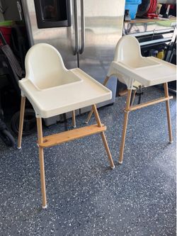 Two ikea high chairs with faux wood leg wraps