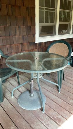 Round outdoor glass table with 2 plastic chairs