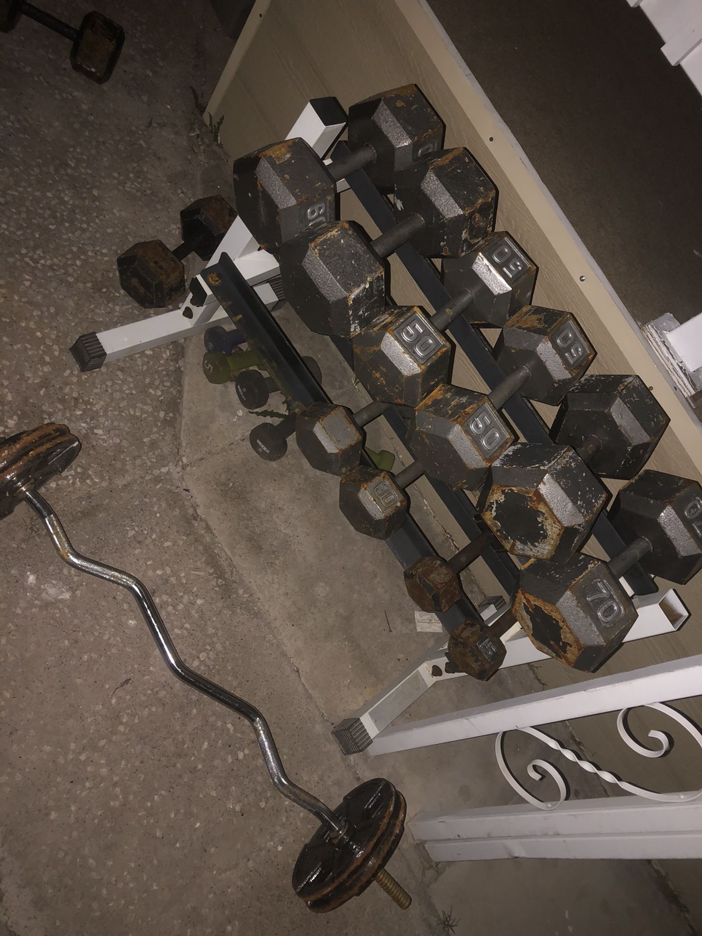 Dumbbells and curling bar whit extra weights and a battle rope