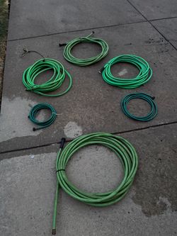 several coiled green hoses in various sizes